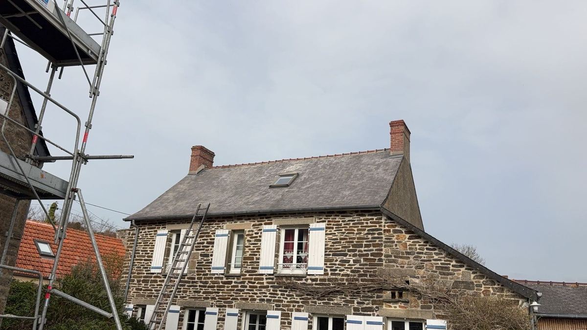 Longère en pierre avec sa toiture en ardoise usée, échafaudage en place avant réfection
